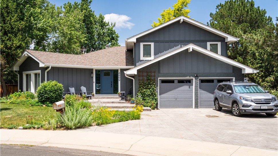 Boulder Home after full reside, window and entry door replacement with all new trim, soffit, fascia and gutters, in primed and painted James Hardie Board and Batten