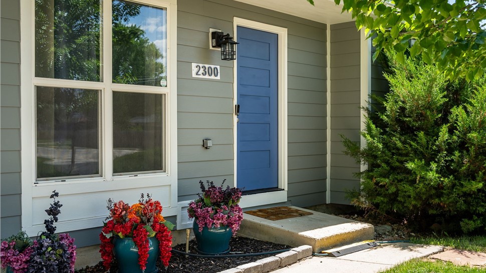 Navy blue Timbergrain fiberglass entry door with Gray Slate James Hardie siding in Longmont, CO