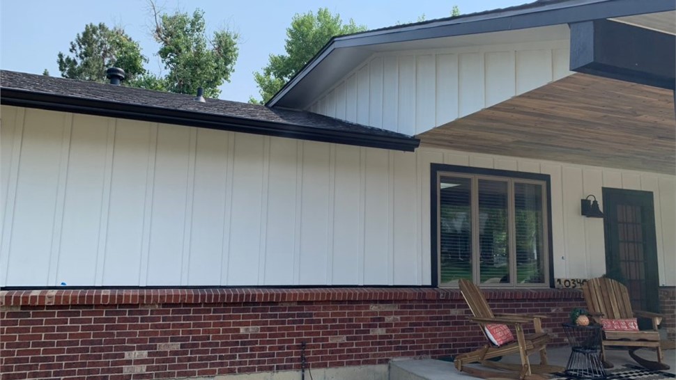 Completed roofing, siding, and window replacement using Arctic White Board and Batten, GAF Armorshield Shingles in Charcoal, and Alside Mezz Vinyl windows in White on home in Westminster Colorado