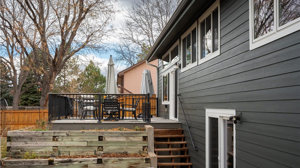 Rear elevation with Iron Gray lap siding, white windows and a sliding patio door above a back deck in Longmont
