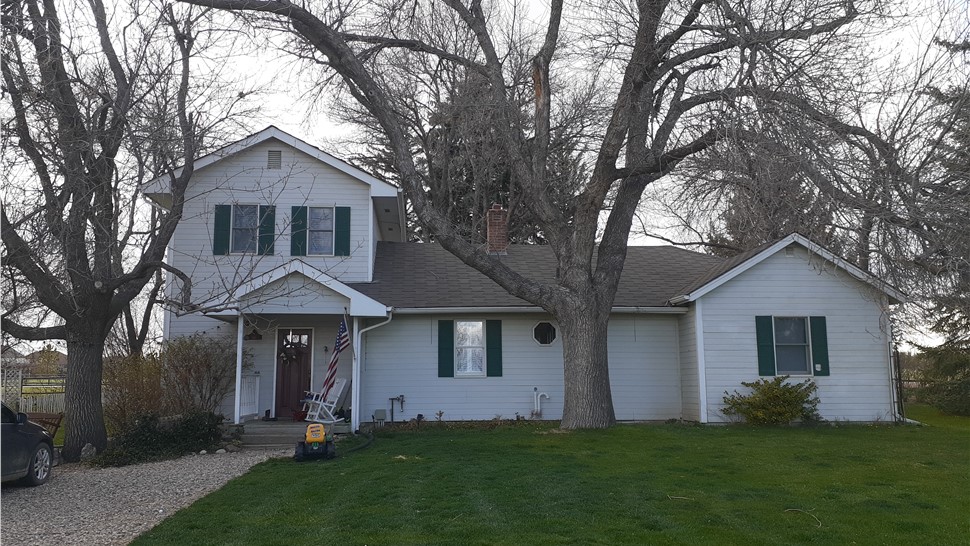 Full exterior of aging homestead home before replacement in Fort Collins Colorado