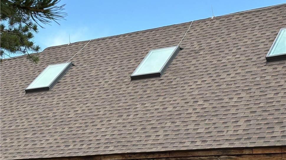 New GAF ArmorShield II shingles in Barkwood around two skylights in Black Hawk