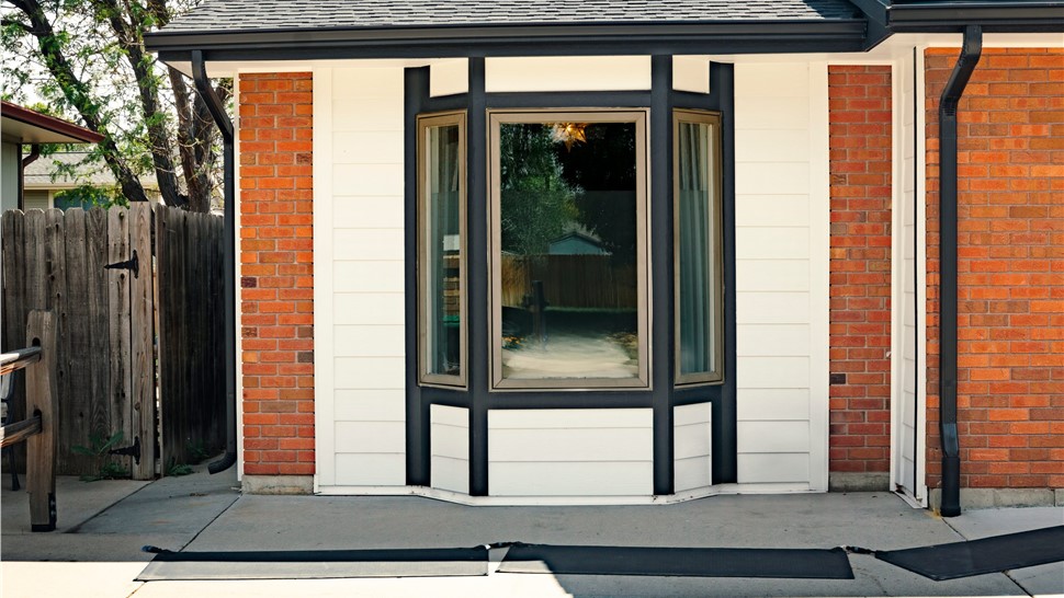 James Hardie Arctic White siding and black Cedarmill trim around a front bay window, Longmont, CO