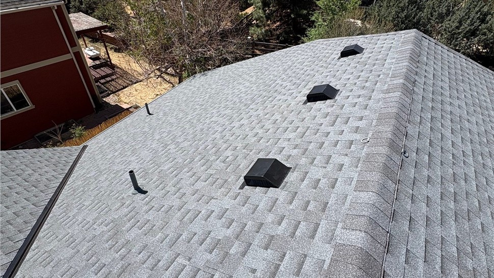 Ridge line view of home after roof replacement with GAF Timberline Armorshield II shingles in Pewter Gray