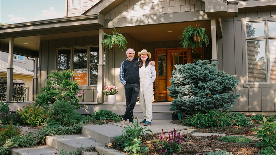 Couple standing in front of their James Hardie siding,GAF roof and gutter installation in Boulder, Colorado