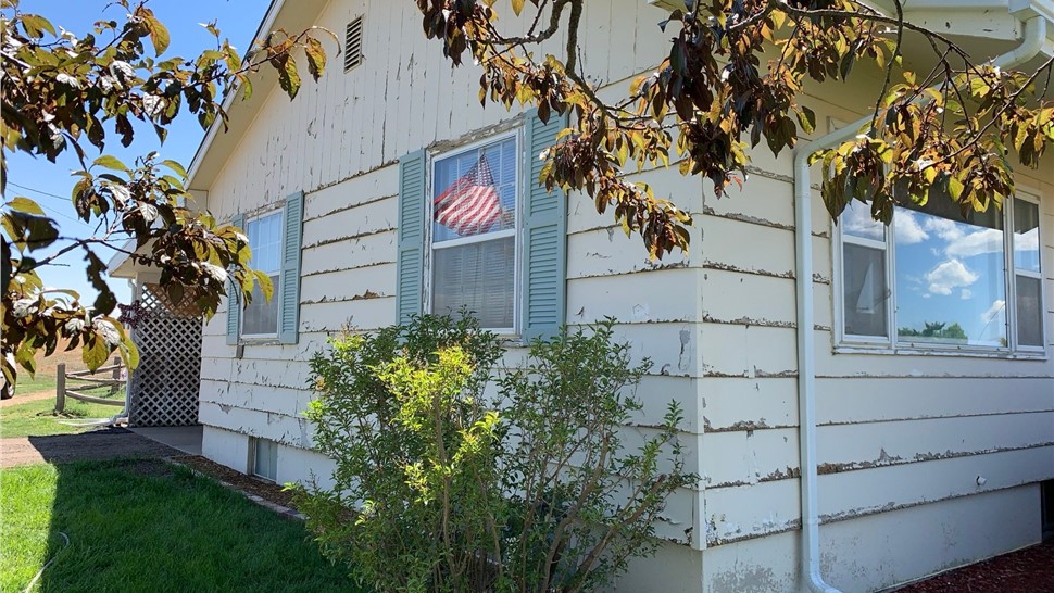 Home in Erie Colorado with wood siding damage and old windows