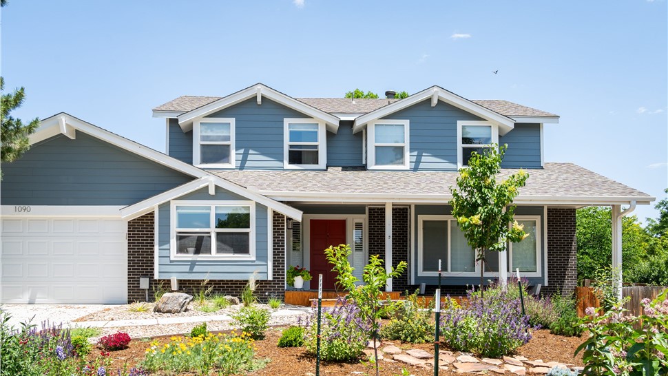 Two-story Longmont home with James Hardie Boothbay Blue lap siding and Arctic White trim above dark brick