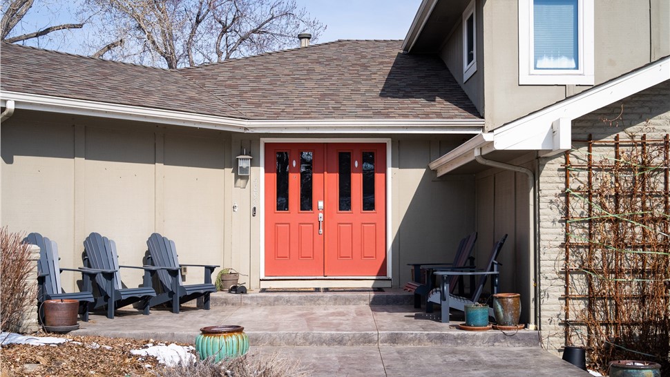 Boulder home before full exterior remodel including new windows, entry door, primed and painted siding,  trim, soffit fascia and gutters