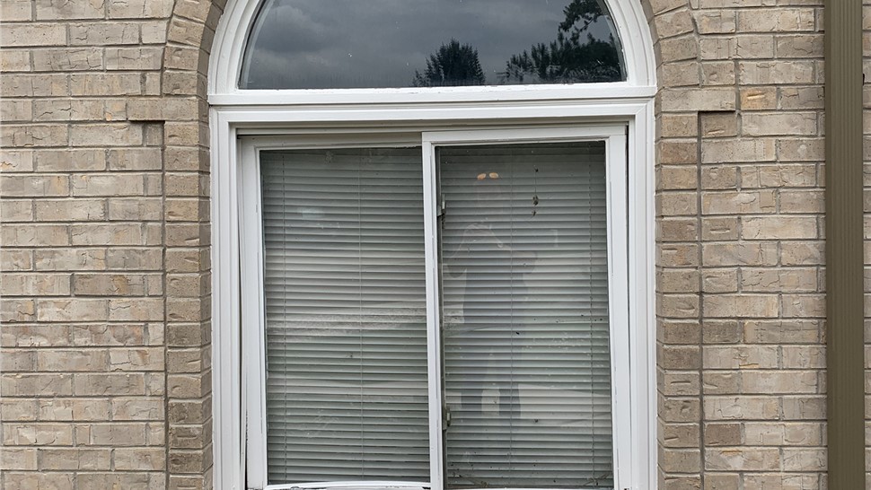 Old wood-frame slider window with visible damage before replacement in Longmont Colorado
