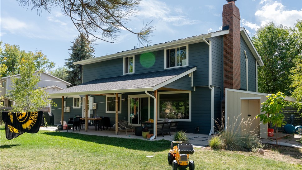 Rear elevation of a Boulder home with new James Hardie siding in Evening Blue and covered patio