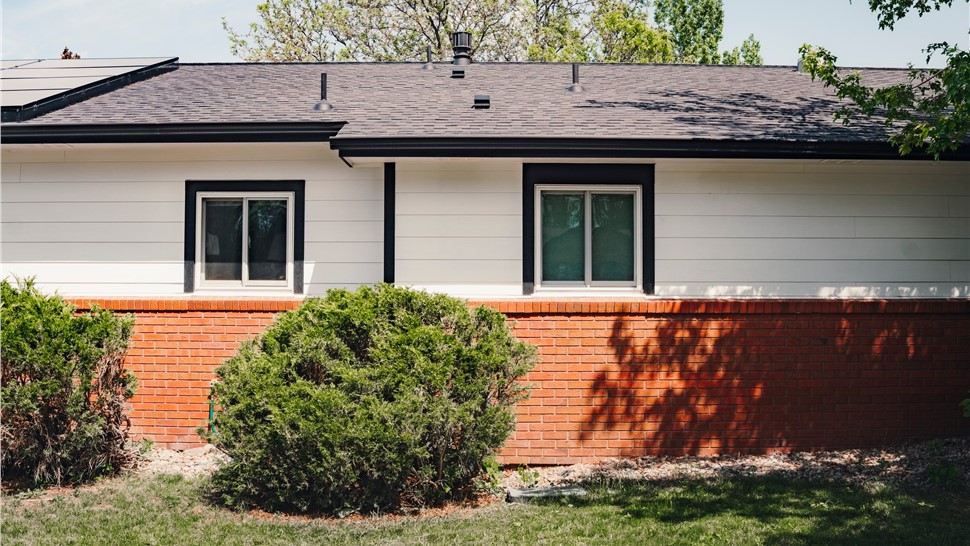James Hardie Arctic White siding and black window trim on a side elevation, Longmont, CO