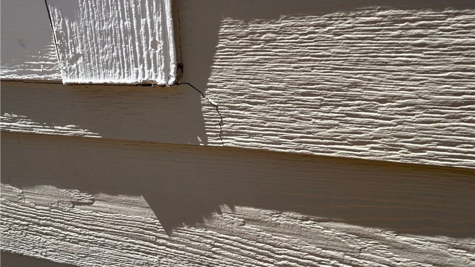 close up image of cracked siding due to overdriven nails in need of replacement