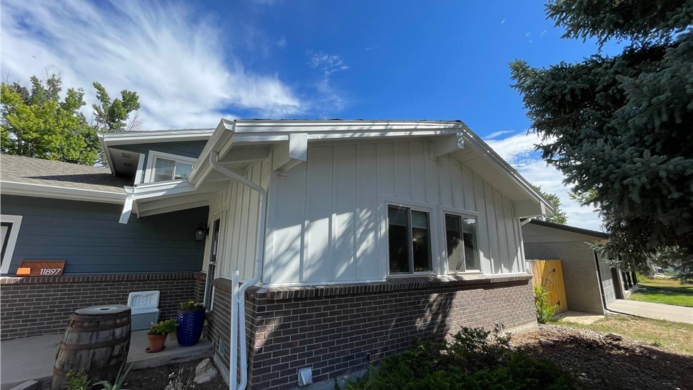 Completed James Hardie siding replacement with Eveni8ng Blue lap siding and Arctic White Board and Batten accents and new gutter system replacement on home in Arvada Colorado
