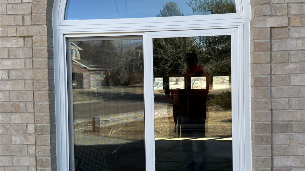 Pella Impervia arched window and slider in brick surround after installation in Longmont Colorado