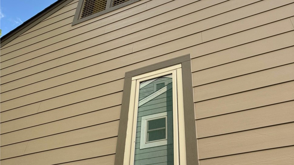 Detailed shot of timber bark trim around window view of completed James Hardie Lap siding install in Louisville Colorado