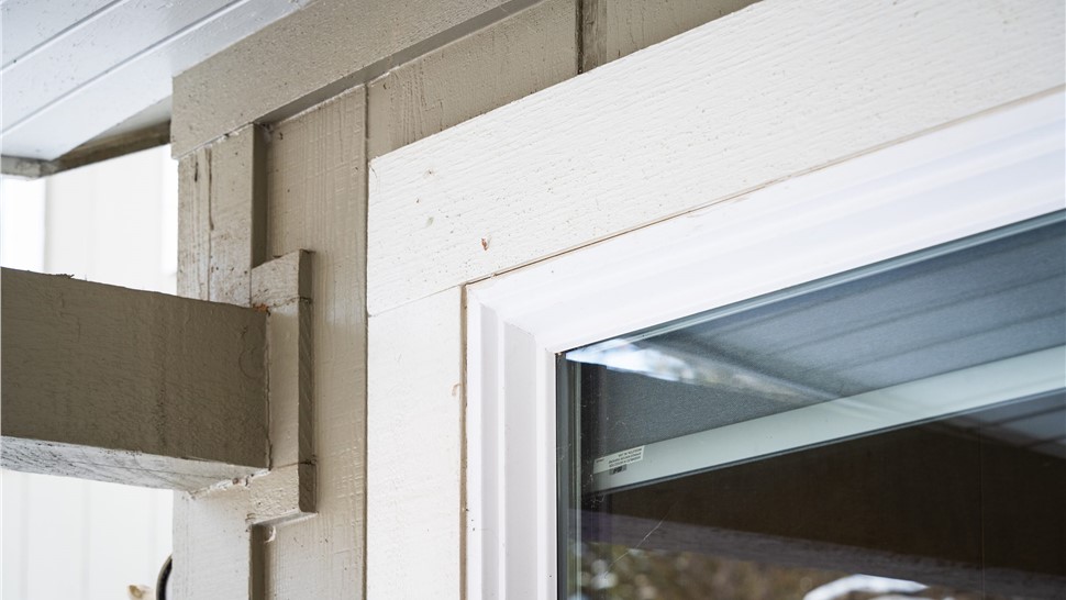 Close up of trim on  Boulder home before full exterior remodel including new windows, entry door, primed and painted siding,  trim, soffit fascia and gutters