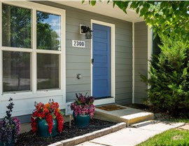 Navy blue Timbergrain fiberglass entry door with Gray Slate James Hardie siding in Longmont, CO