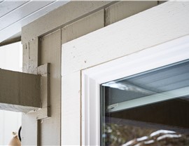 Close up of trim on  Boulder home before full exterior remodel including new windows, entry door, primed and painted siding,  trim, soffit fascia and gutters